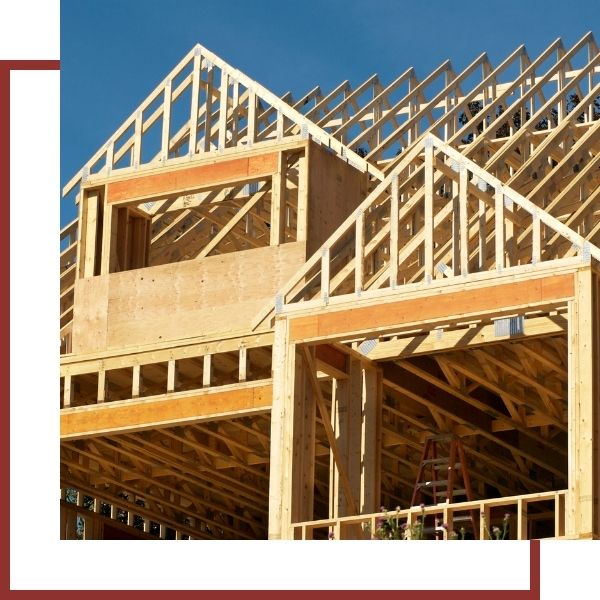 Wooden house frame under construction with blue sky background
