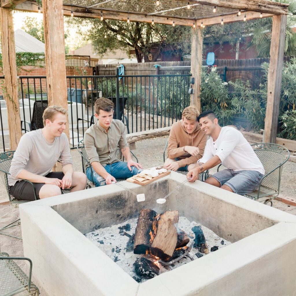 people sitting in backyard roasting marshmellows
